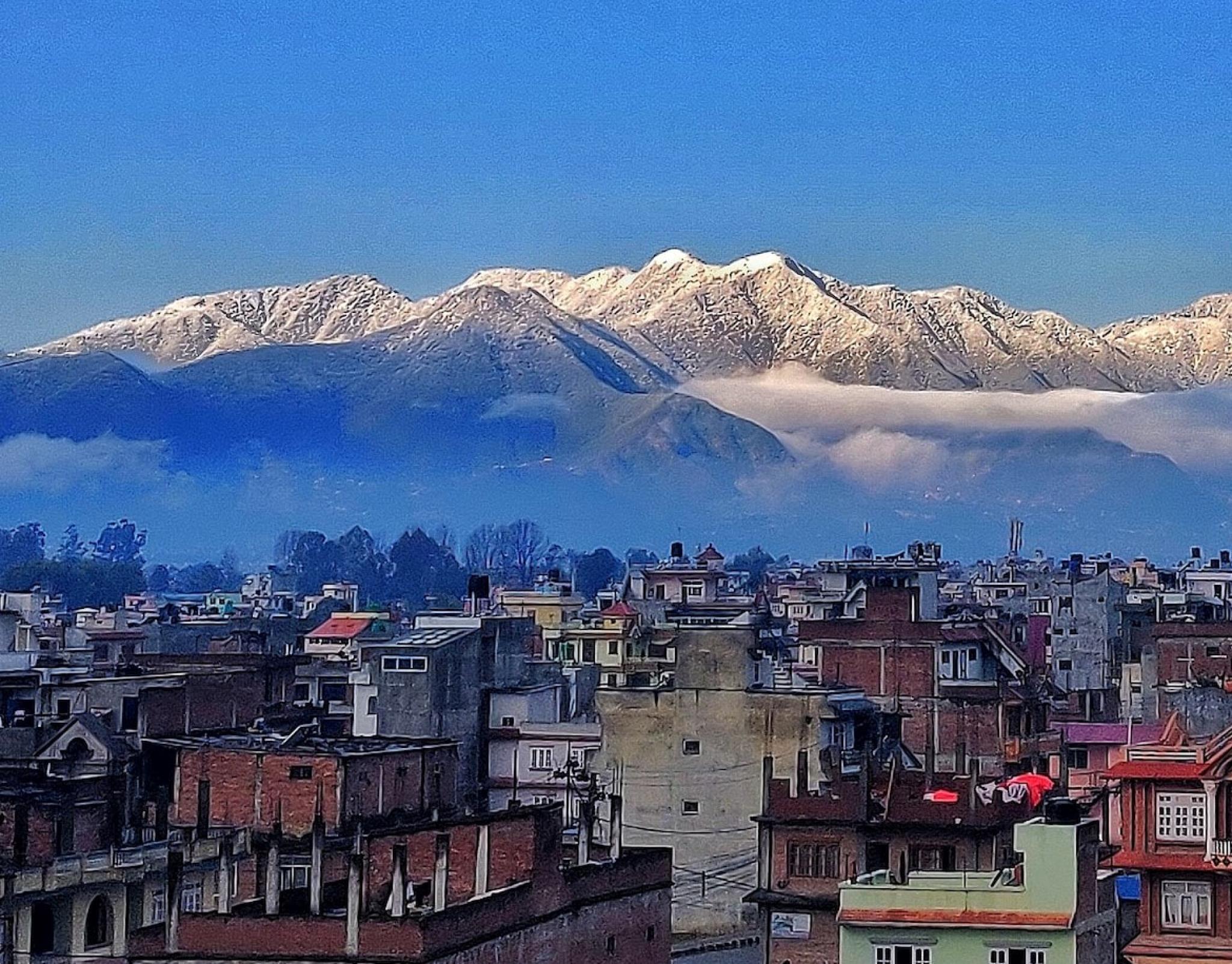 nepali city with himalayas in background