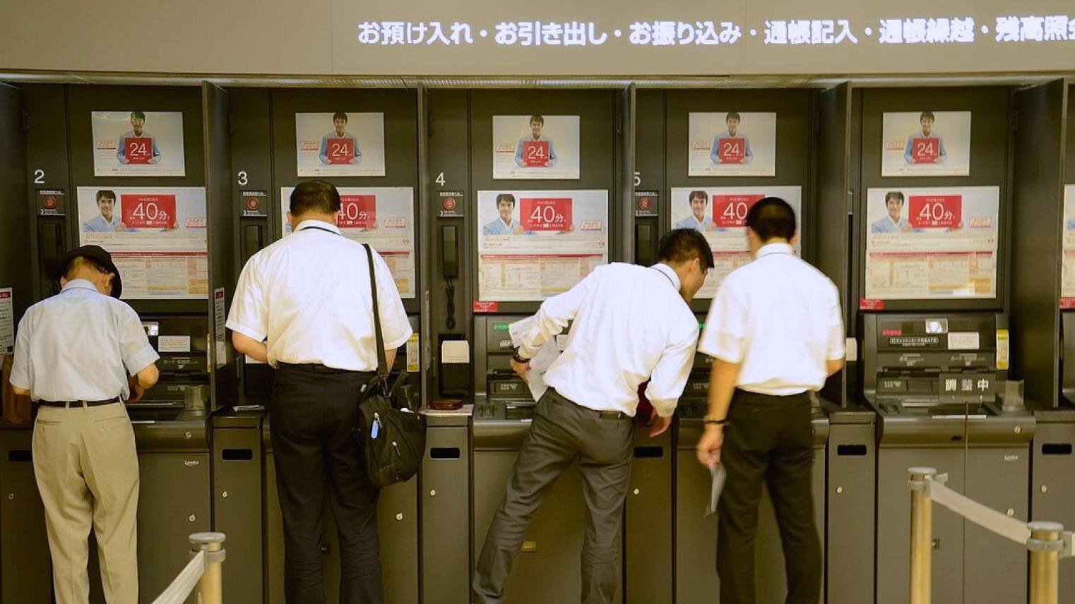 Japanese men withdrawing cash